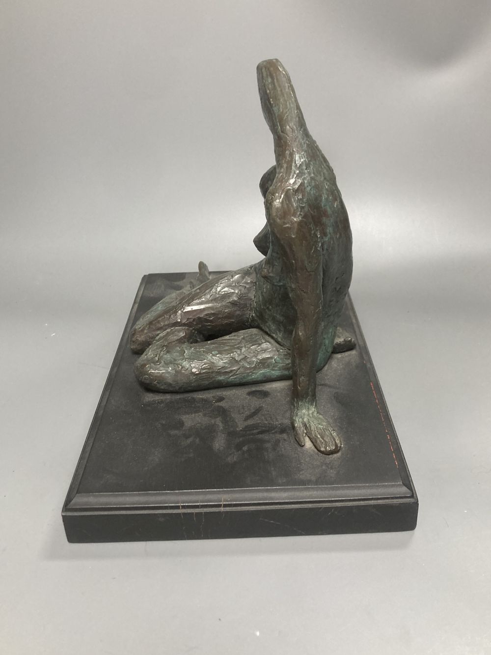 A contemporary bronze figure of a seated female figure, ebonised plinth 29.5cm wide